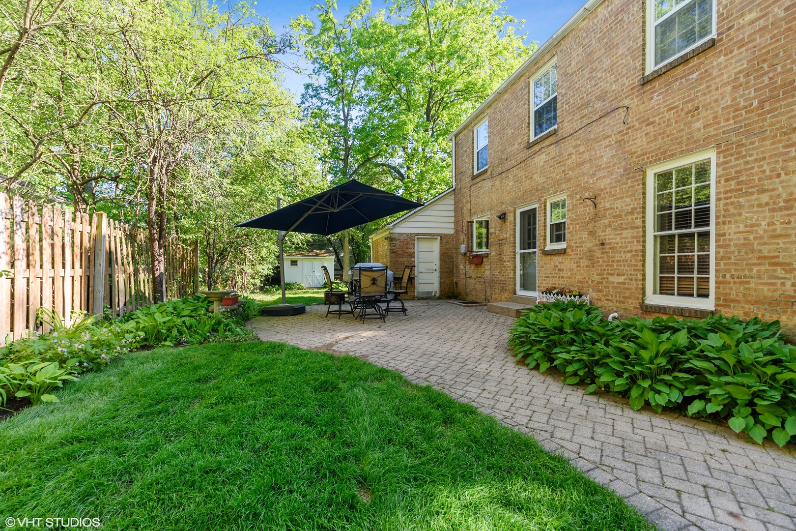 181 Ridge Road Highland Park, IL 60035 - Photo 10 of 16 a view of a patio with chair and table and chairs under an umbrella with large trees