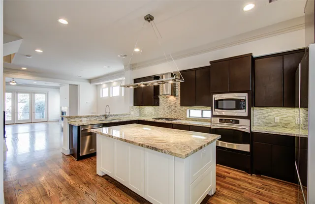 a kitchen with stainless steel appliances granite countertop a sink stove and refrigerator