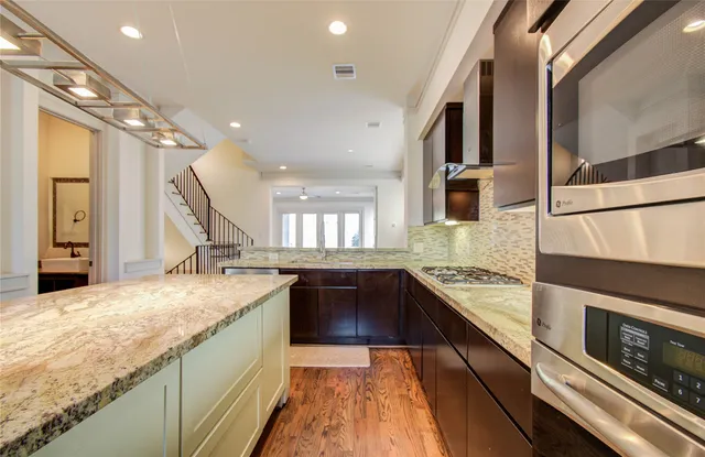 a kitchen with stainless steel appliances granite countertop a sink and a stove top oven