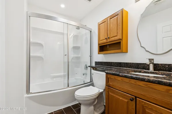 a bathroom with a granite countertop toilet sink and shower