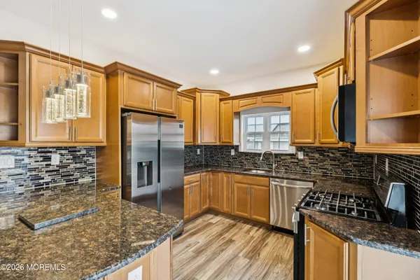 a kitchen with stainless steel appliances granite countertop a sink stove and refrigerator