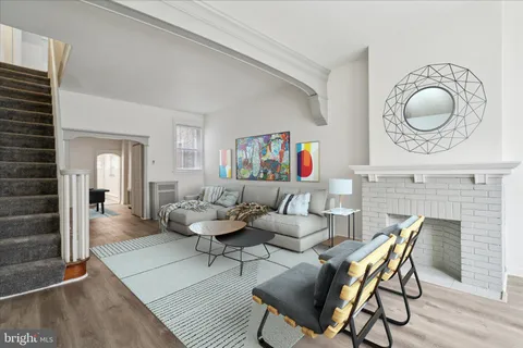 a living room with fireplace furniture and a wooden floor