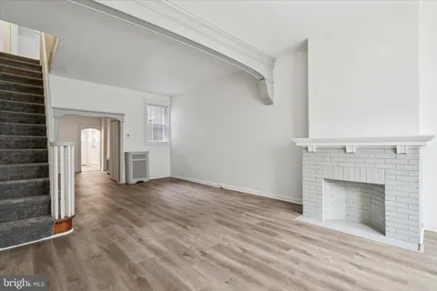 a view of empty room with wooden floor and fireplace
