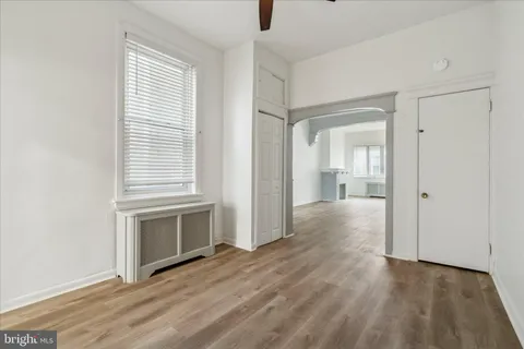 a view of empty room with wooden floor and fireplace