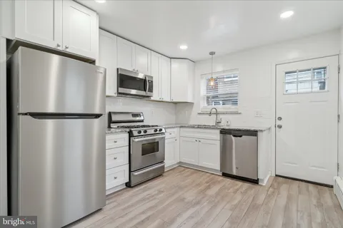 a kitchen with stainless steel appliances a refrigerator stove and microwave
