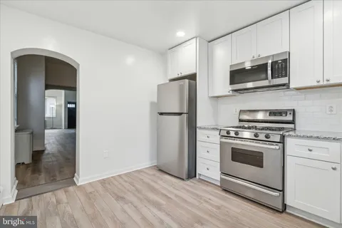 a kitchen with stainless steel appliances granite countertop a stove a refrigerator and a microwave
