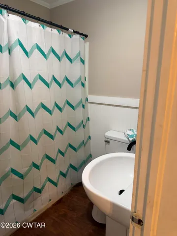 a bathroom with a sink and mirror with toilet