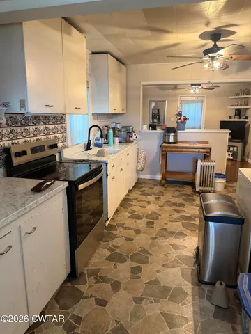 a kitchen with a sink a counter top space appliances and a window