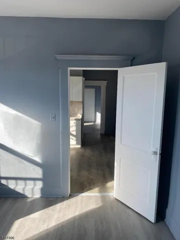 a view of a hallway with wooden floor and a living room