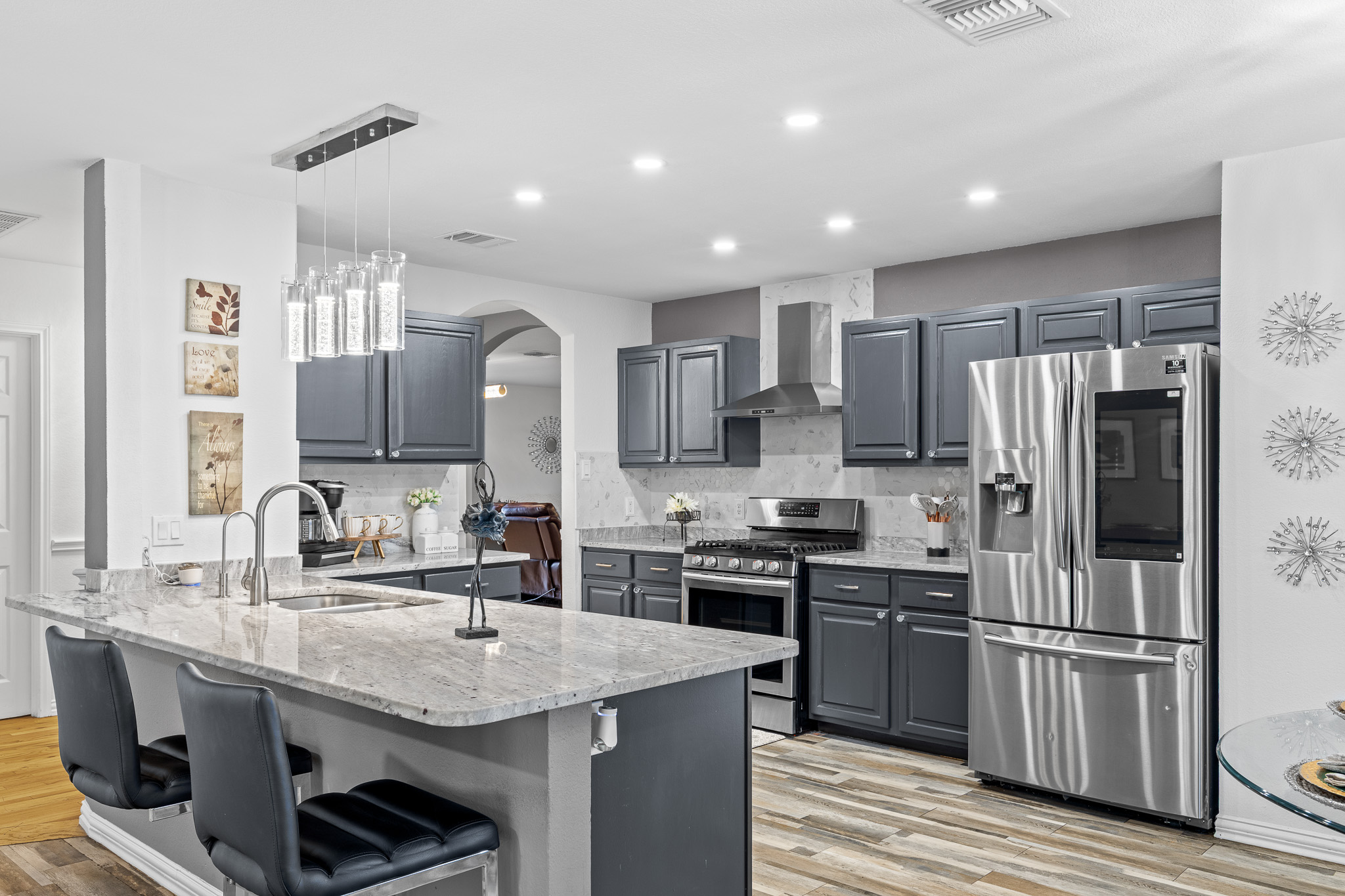 615 Barbara Way Bastrop, TX 78602 - Photo 5 of 27 a kitchen with granite countertop a sink stove and refrigerator