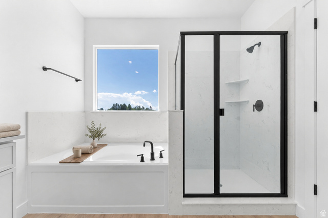 2362 1400 West, Unit 14 Perry, UT 84302 - Photo 11 of 22 Soaking tub with black-finish fixtures, white tile surround, and a large window