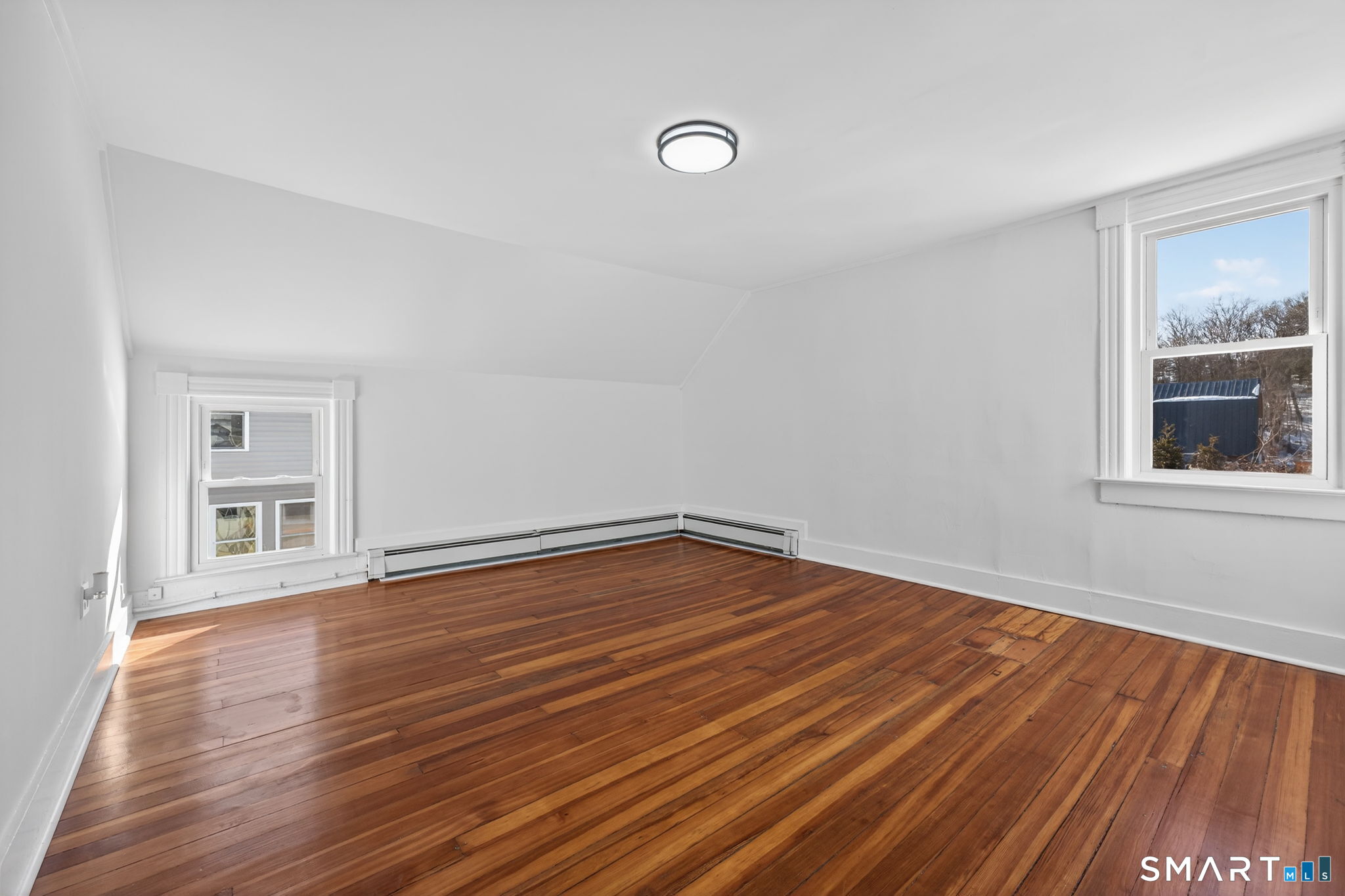 119 Taftville-Occum Road Norwich, CT 06360 - Photo 15 of 27 a view of an empty room with wooden floor and a window
