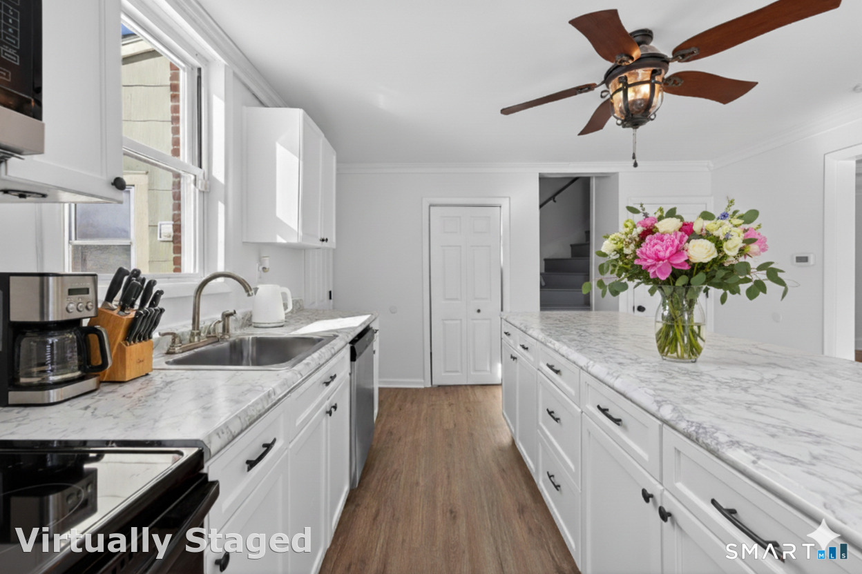 119 Taftville-Occum Road Norwich, CT 06360 - Photo 4 of 27 a kitchen with stainless steel appliances granite countertop a sink dishwasher and white cabinets with wooden floor