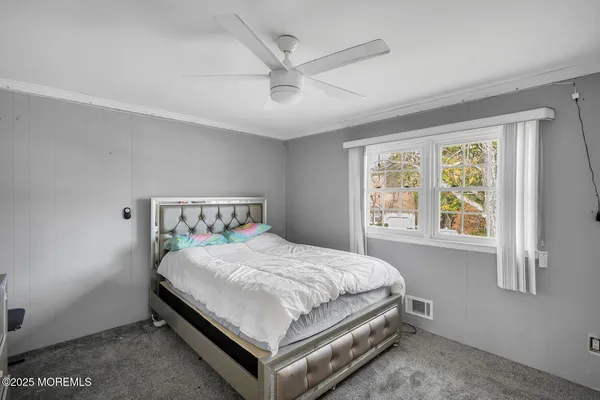 a bed sitting in a bedroom next to a window