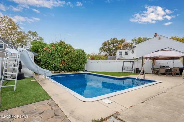 a view of a swimming pool with lawn chairs under an umbrella