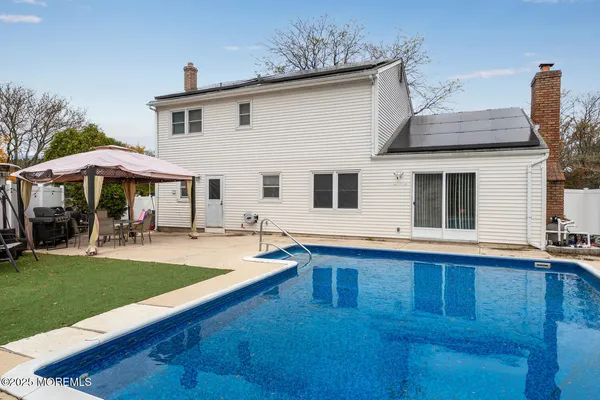 a view of a white house with a swimming pool