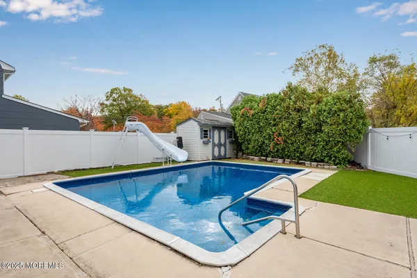 a swimming pool with outdoor seating and yard