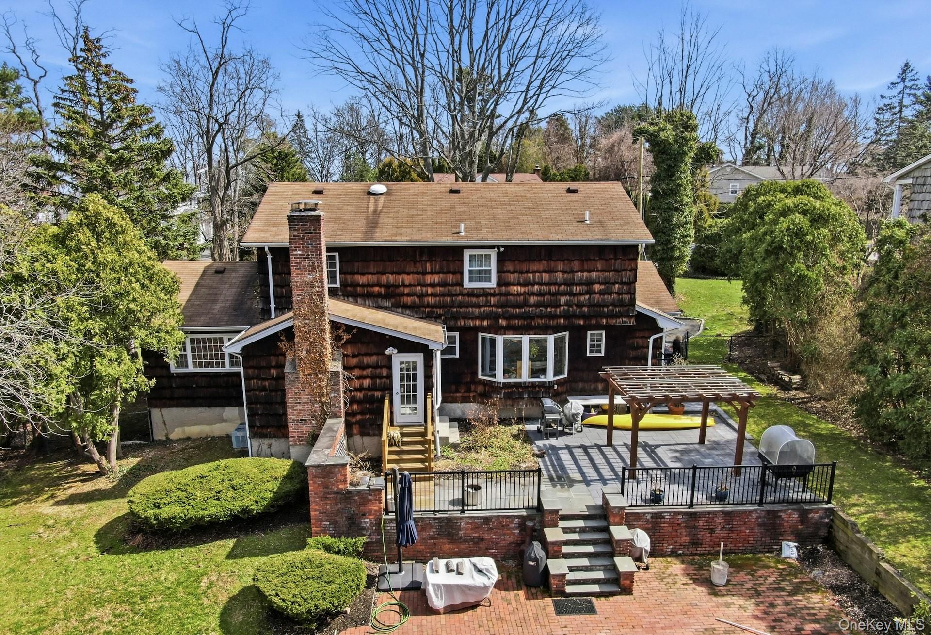 35 East Neck Road Huntington, NY 11743 - Photo 27 of 41 a view of a big house with large trees and lawn chairs