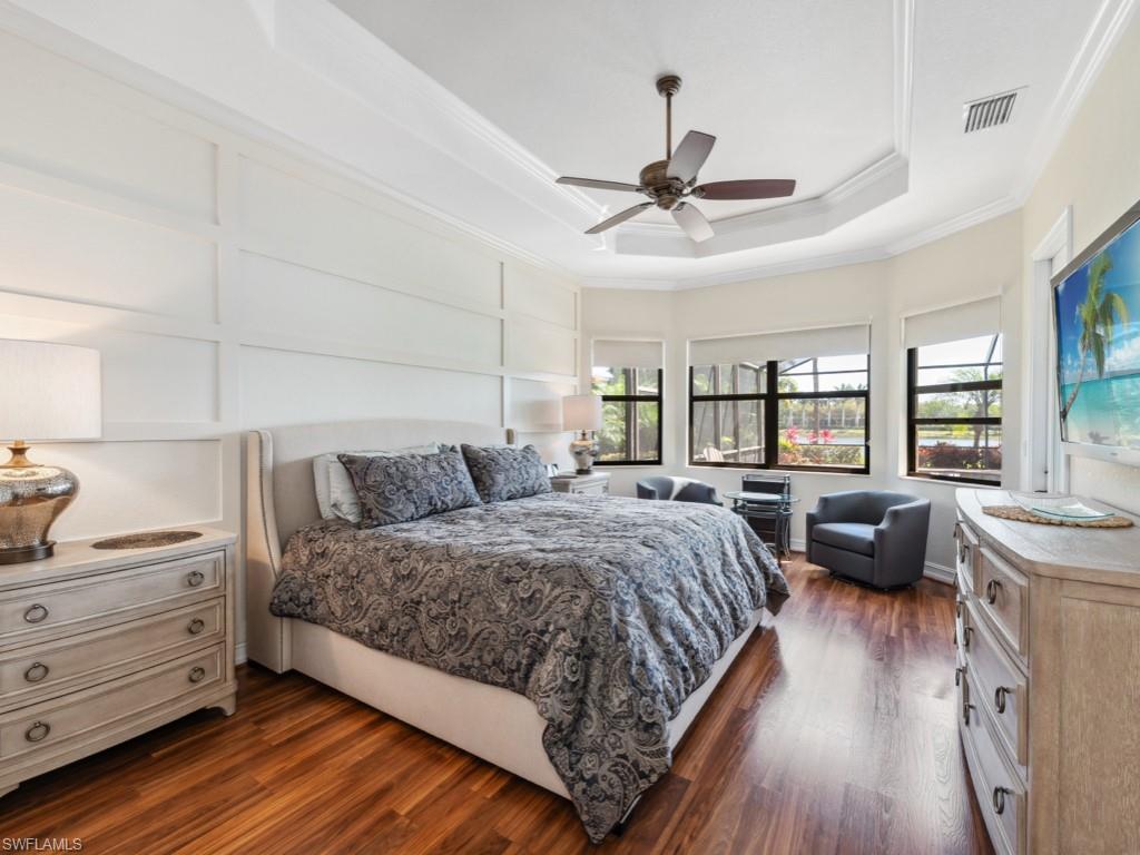 9430 Italia Way Naples, FL 34113 - Photo 14 of 47 Bedroom with crown molding, dark wood-style floors, visible vents, and a tray ceiling