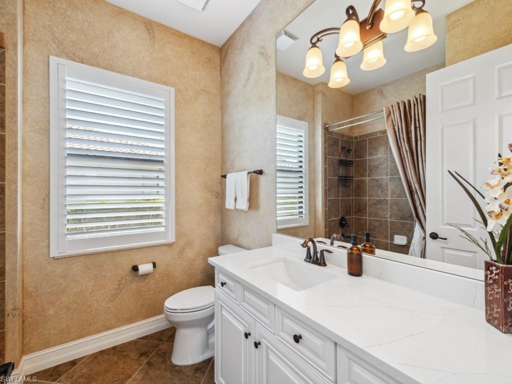 9430 Italia Way Naples, FL 34113 - Photo 20 of 47 Full bath with tile patterned floors, baseboards, tiled shower, and toilet