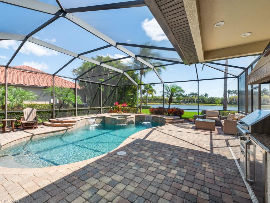 9430 Italia Way Naples, FL 34113 - Photo 24 of 47 View of swimming pool featuring an outdoor hangout area, a patio area, a water view, glass enclosure, and a pool with connected hot tub