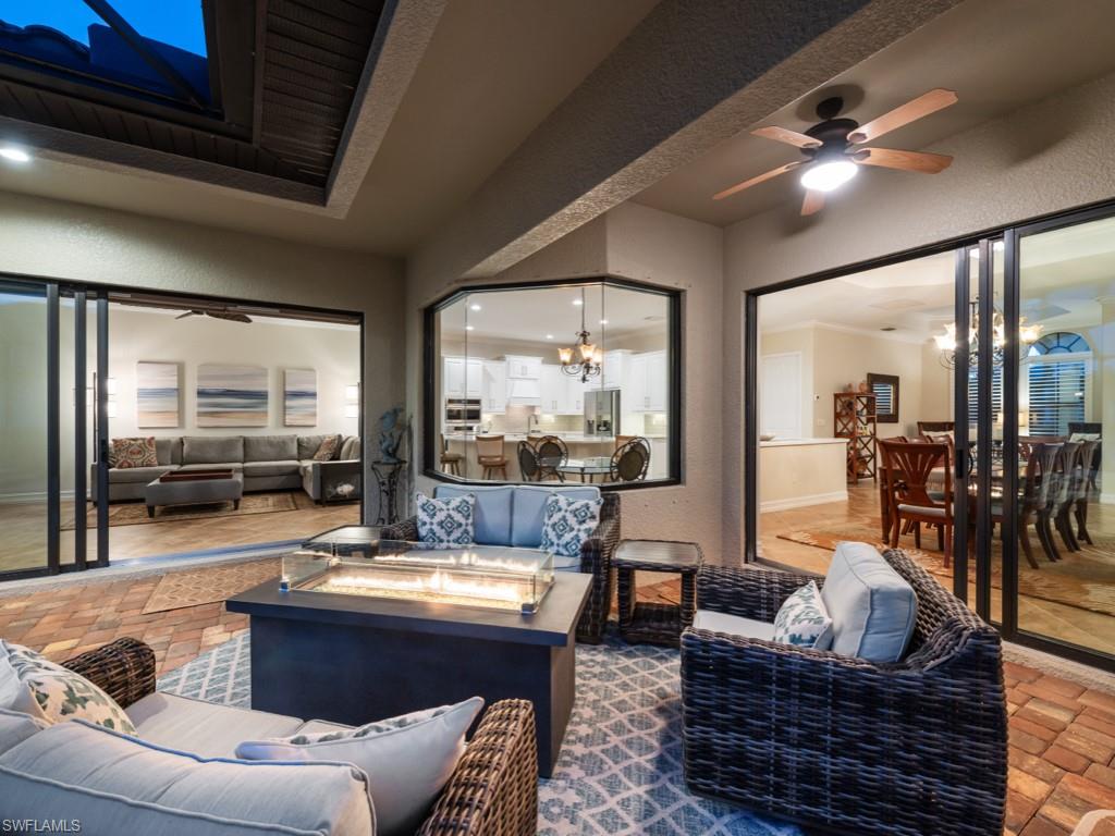 9430 Italia Way Naples, FL 34113 - Photo 29 of 47 View of patio / terrace featuring ceiling fan, outdoor dining space, and an outdoor living space with a fire pit