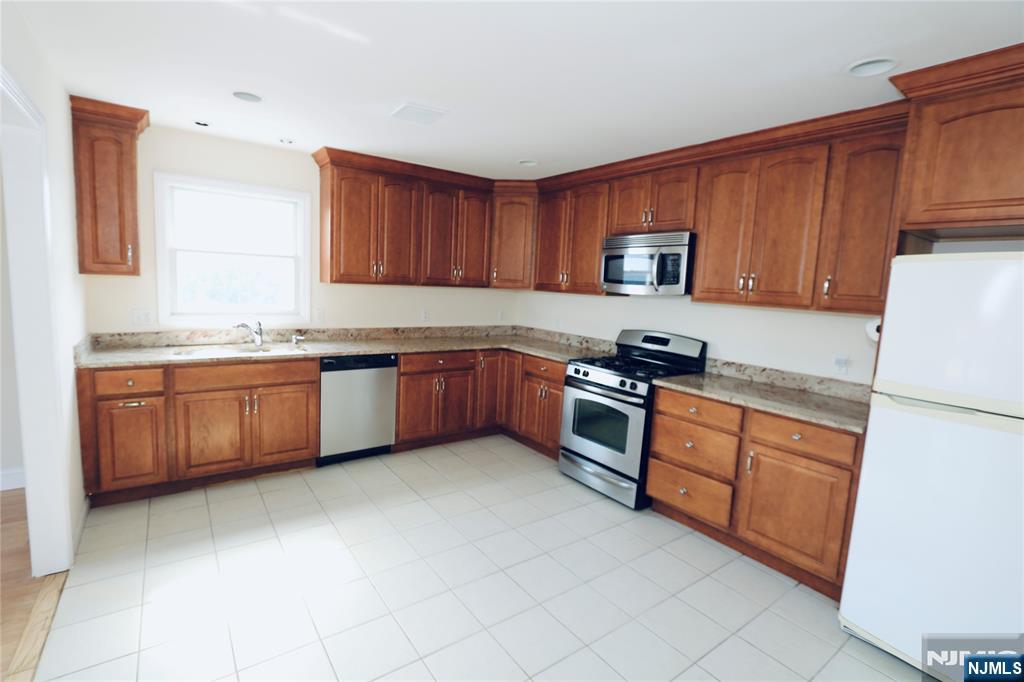 23 Main Avenue Wallington, NJ 07057 - Photo 10 of 29 a kitchen with stainless steel appliances granite countertop a stove sink and cabinets