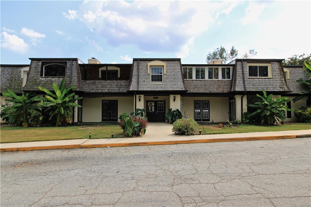 a front view of a house with a yard and plants