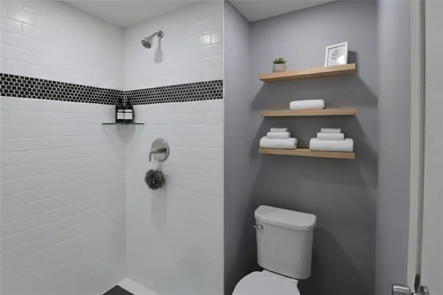 a bathroom with a toilet and a shower