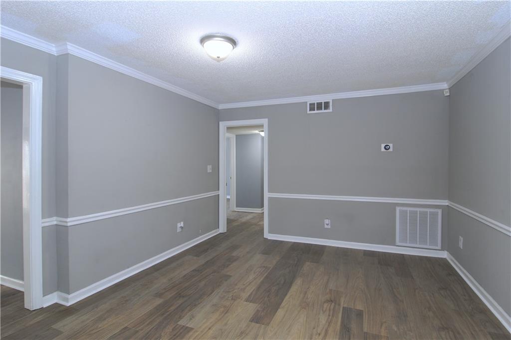 122 Rue Fontaine Lithonia, GA 30038 - Photo 7 of 36 a view of an empty room with wooden floor