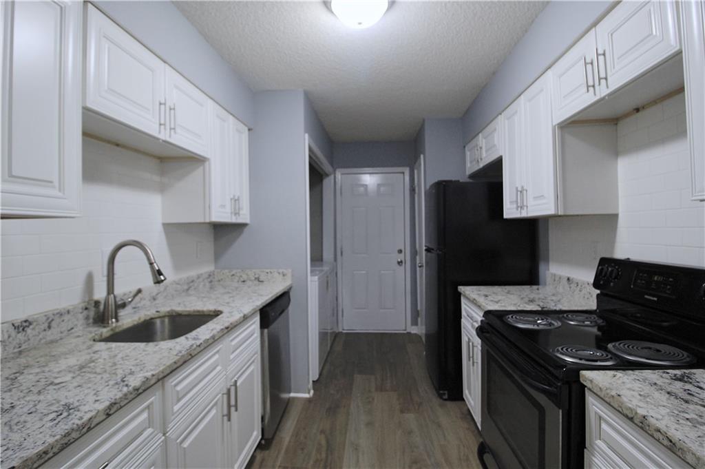 122 Rue Fontaine Lithonia, GA 30038 - Photo 10 of 36 a kitchen with stainless steel appliances granite countertop a sink stove and refrigerator