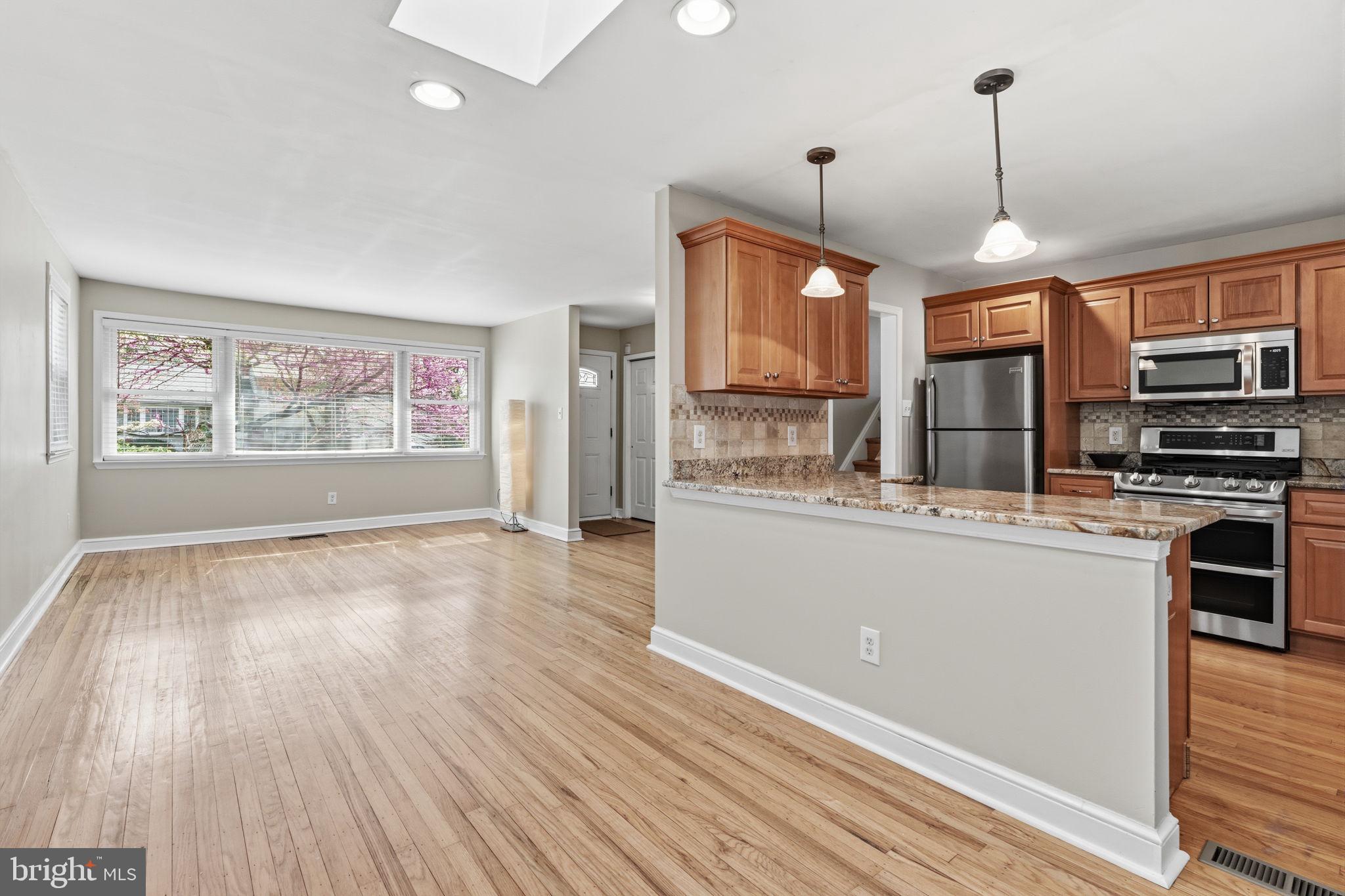 502 Stevens Road Morrisville, PA 19067 - Photo 8 of 37 a kitchen with stainless steel appliances granite countertop a refrigerator a oven a stove and a wooden floors