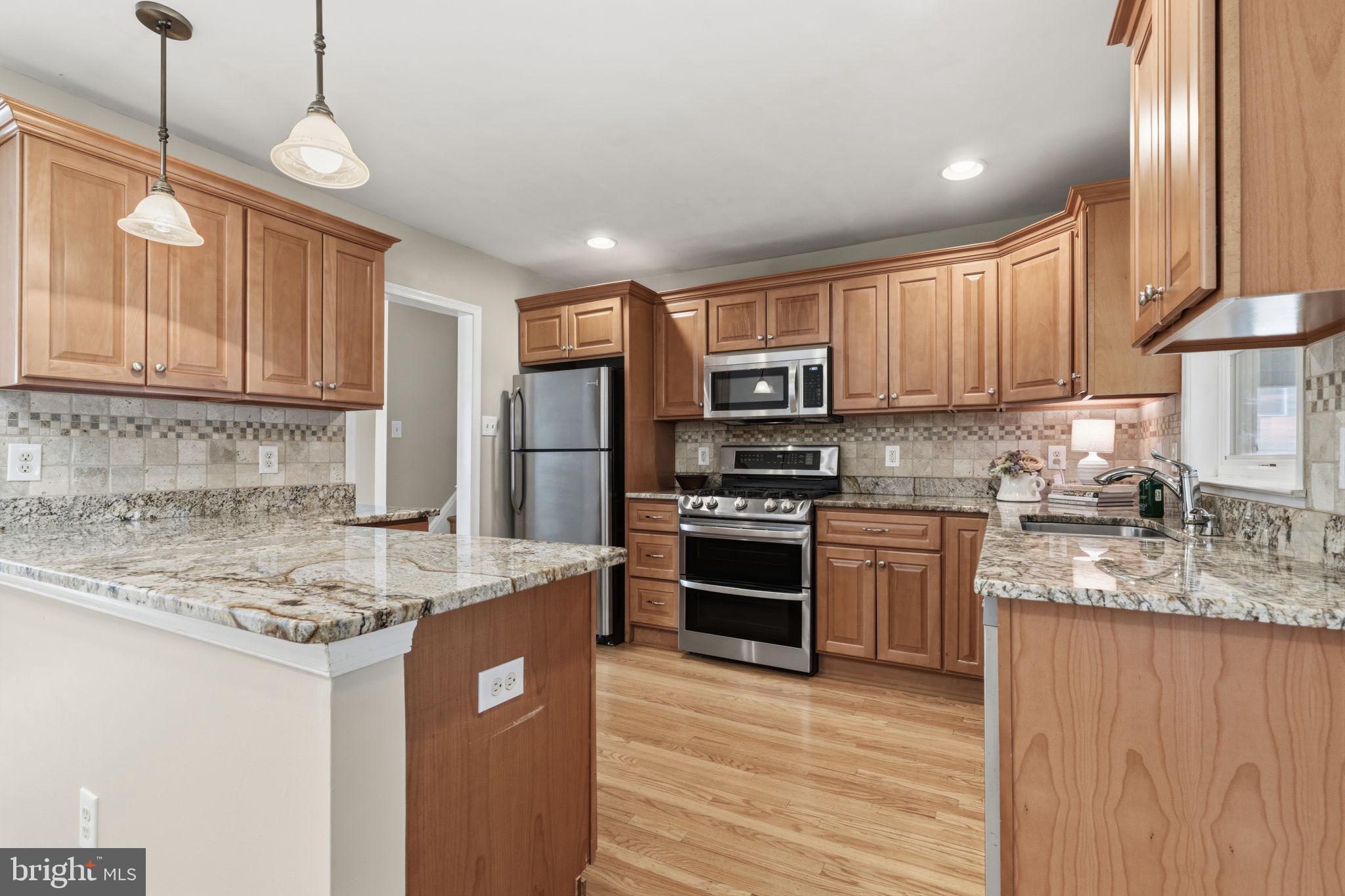 502 Stevens Road Morrisville, PA 19067 - Photo 10 of 37 a kitchen with kitchen island granite countertop a sink cabinets and stainless steel appliances