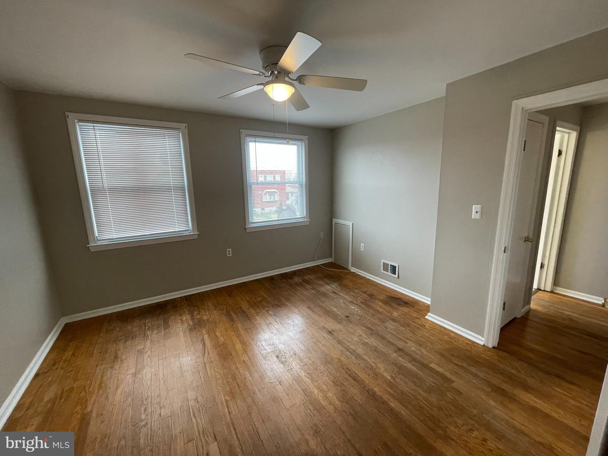 8134 Gray Haven Road Baltimore, MD 21222 - Photo 12 of 30 an empty room with wooden floor and windows