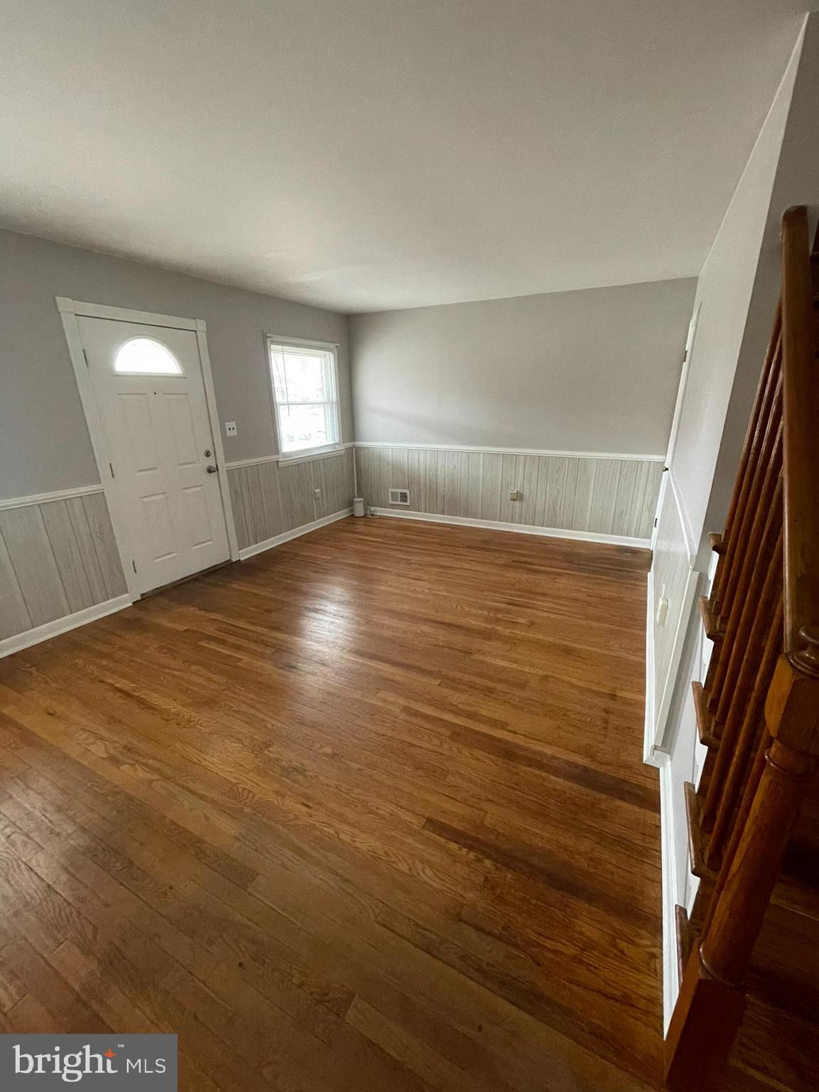 8134 Gray Haven Road Baltimore, MD 21222 - Photo 3 of 30 an empty room with wooden floor and windows