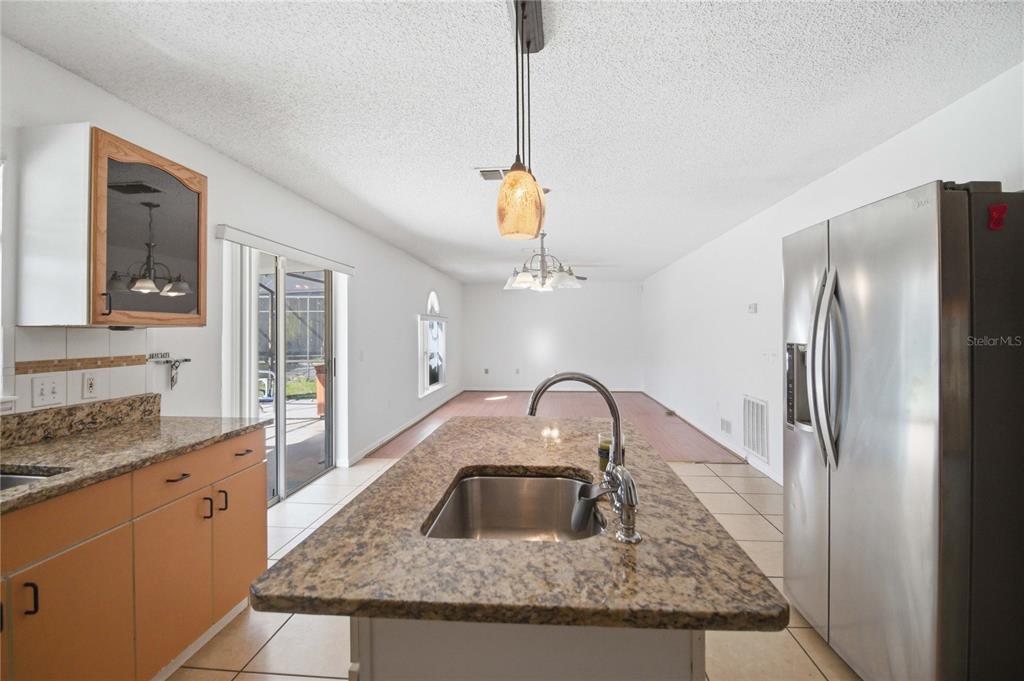 206 Taranto Way Kissimmee, FL 34758 - Photo 14 of 45 a kitchen with a sink granite counter tops and a view of living room
