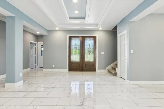 a view of a hallway with dining area and glass doors