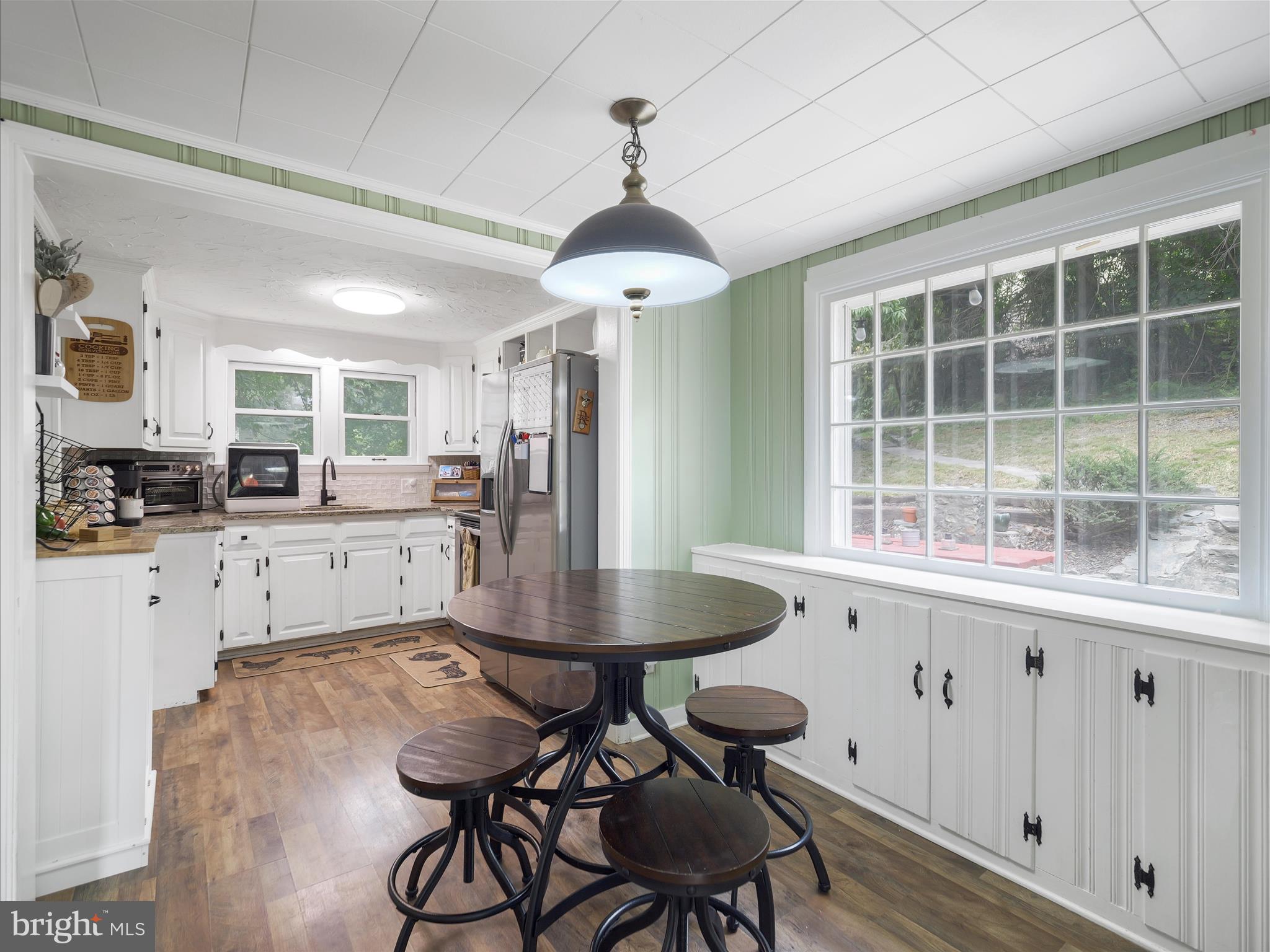 2550 Iron Springs Road Fairfield, PA 17320 - Photo 10 of 32 a kitchen with stainless steel appliances granite countertop a stove a refrigerator a sink dishwasher a dining table and chairs with wooden floor