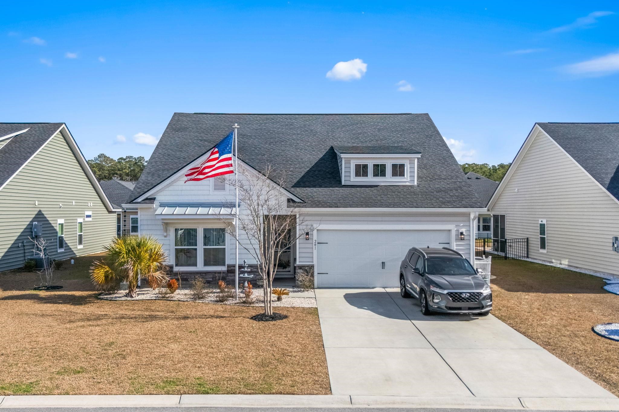 201 Craigflower Court Longs, SC 29568 - Photo 28 of 35 View of front of house with roof with shingles, concrete driveway, stone siding, and a front lawn