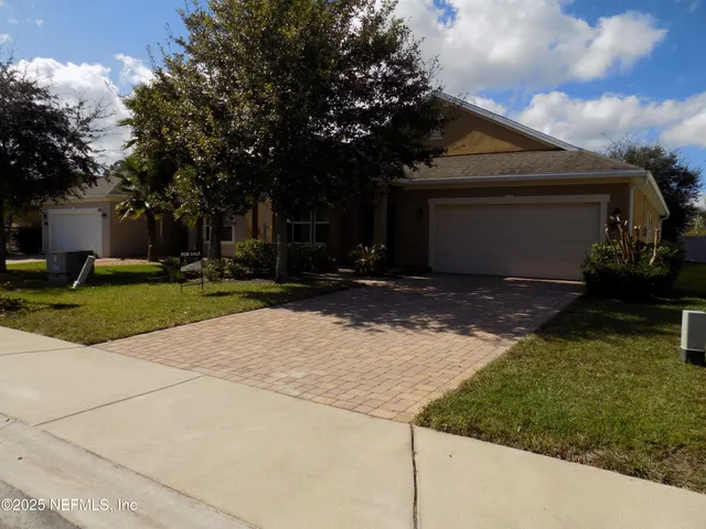 a view of a house with backyard and tree s