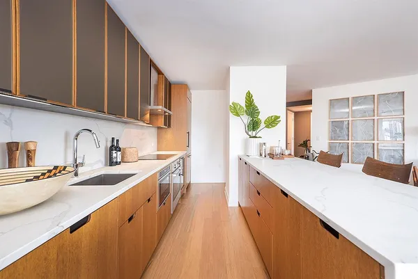 a large kitchen with stainless steel appliances granite countertop a sink and dishwasher a stove top oven with wooden floor