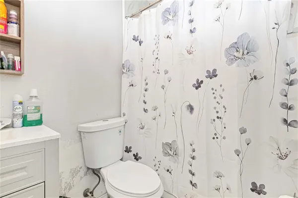 a white toilet sitting next to a bathroom sink