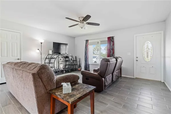 a living room with furniture a ceiling fan and a wooden floor