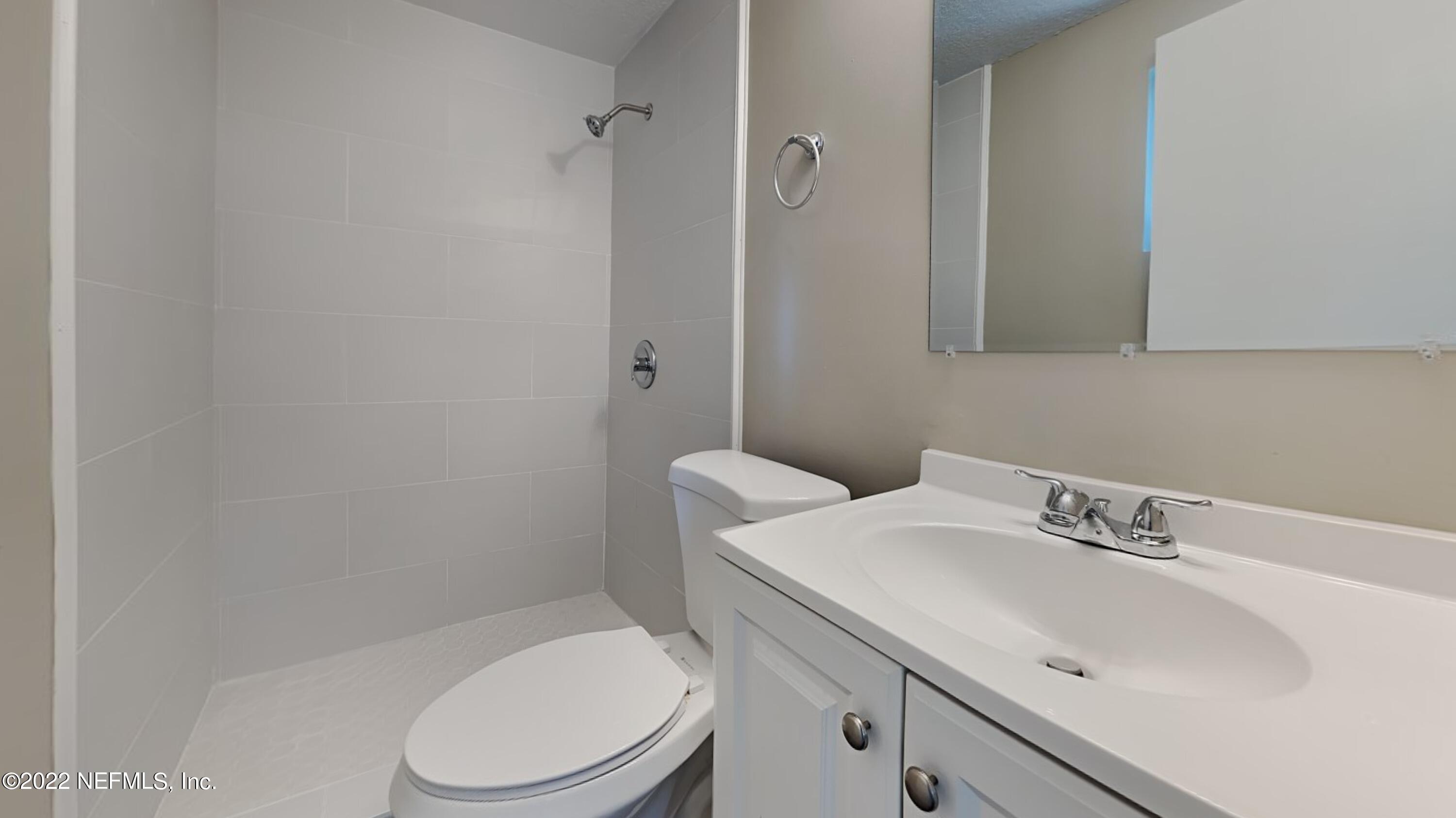 10729 Tulsa Road Jacksonville, FL 32218 - Photo 11 of 21 a bathroom with a sink a toilet and a mirror