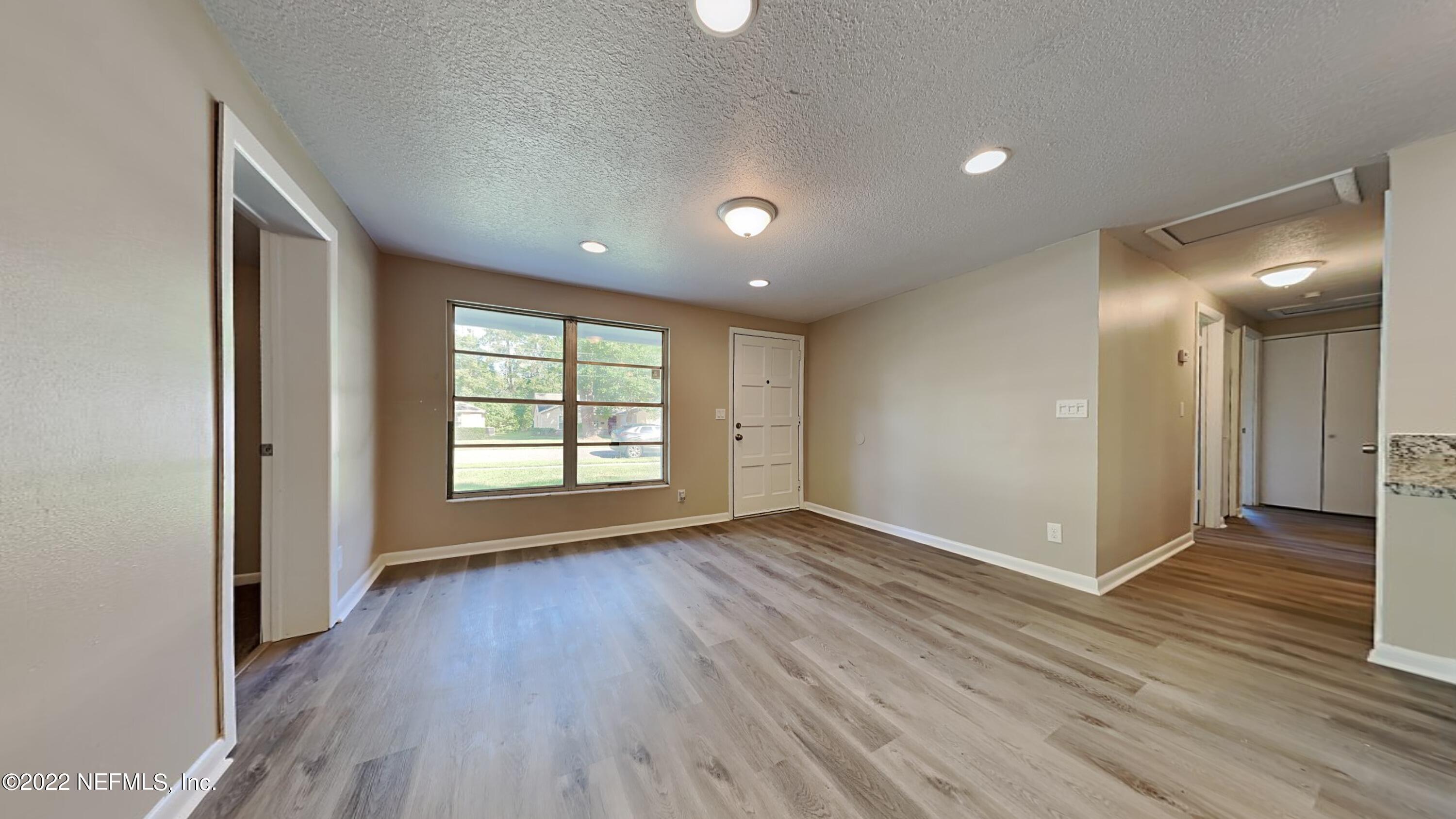 10729 Tulsa Road Jacksonville, FL 32218 - Photo 3 of 21 a view of an empty room with glass door and wooden floor