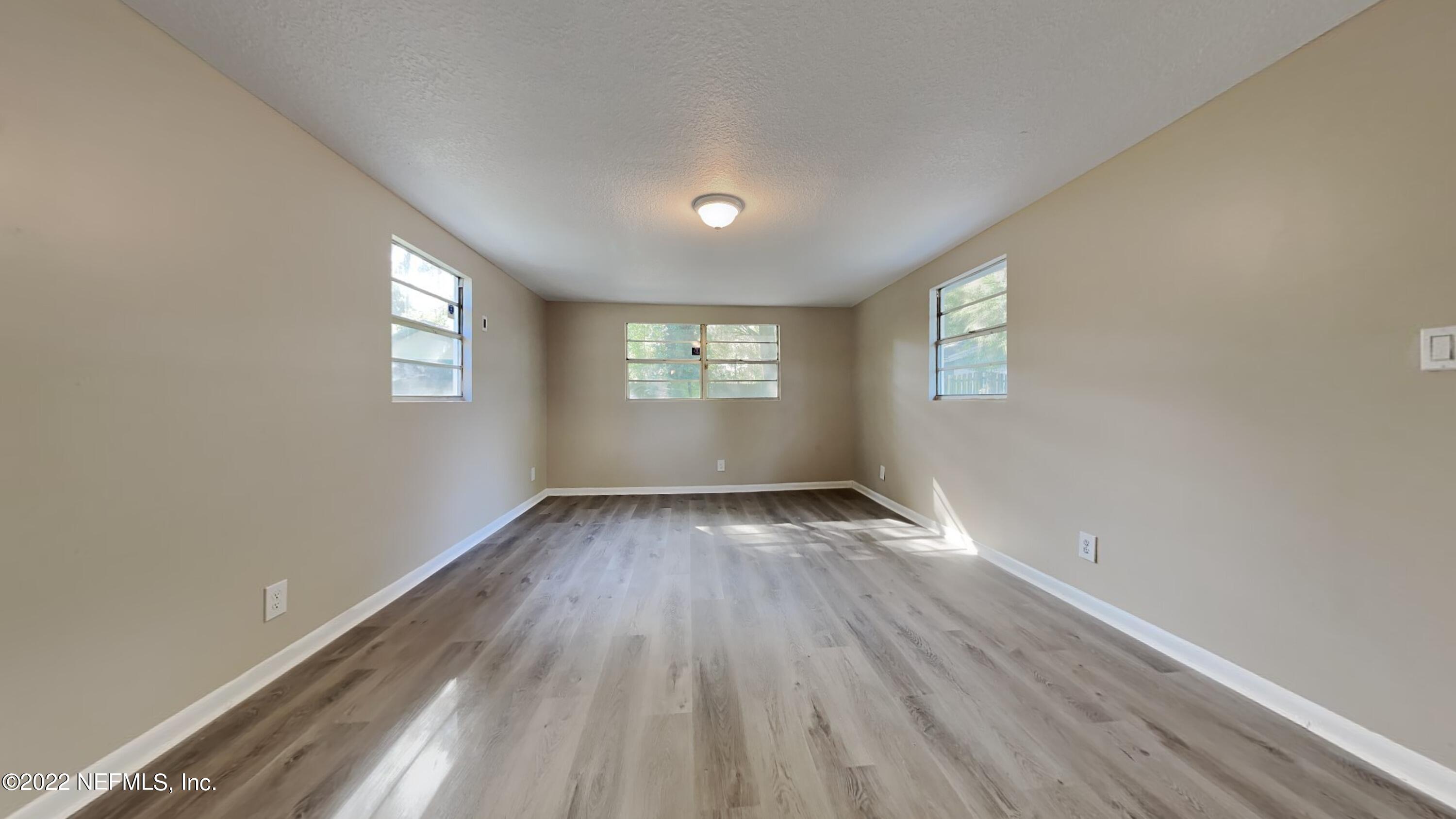 10729 Tulsa Road Jacksonville, FL 32218 - Photo 4 of 21 a view of an empty room with wooden floor and window