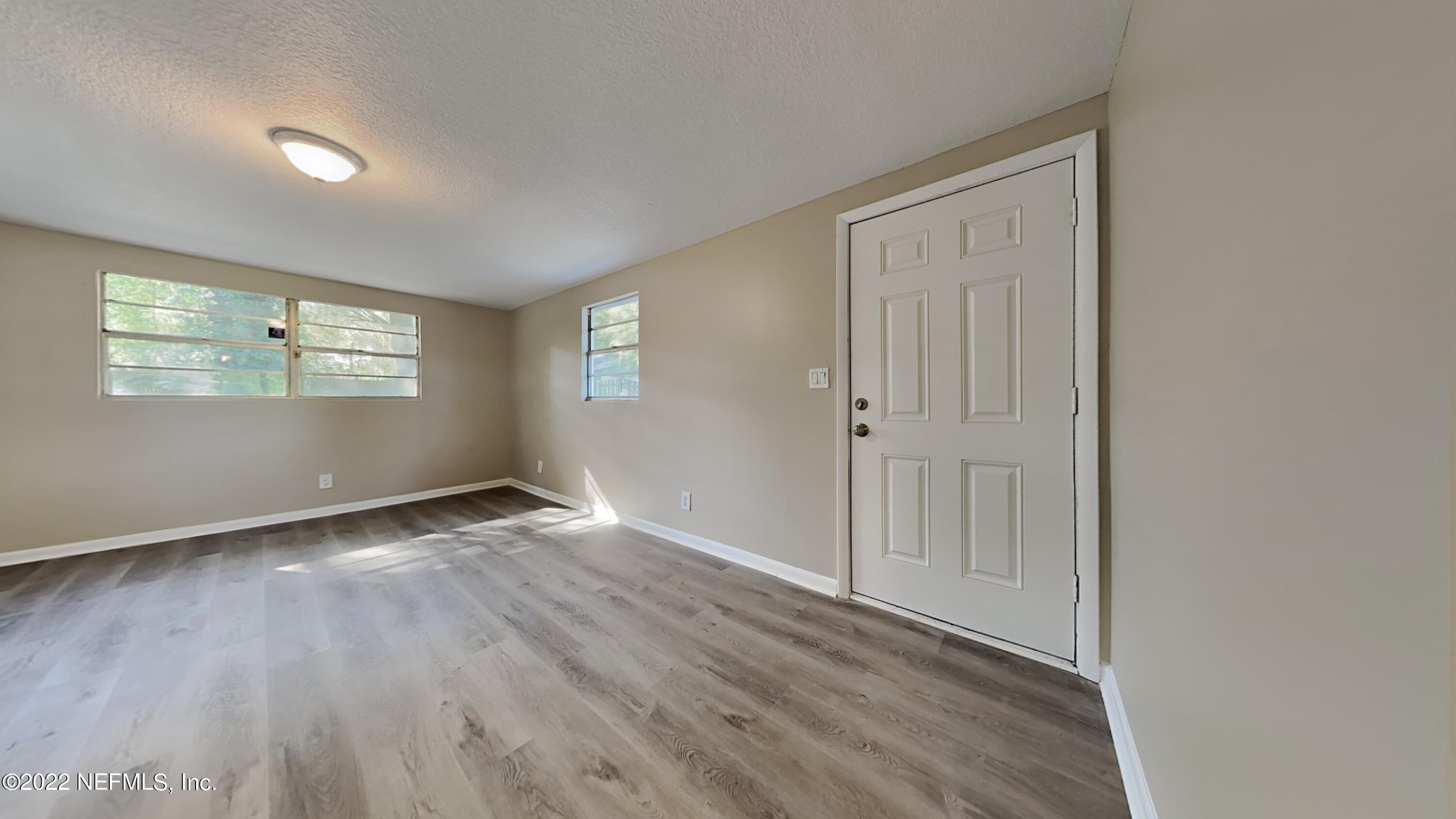 10729 Tulsa Road Jacksonville, FL 32218 - Photo 5 of 21 an empty room with wooden floor and windows