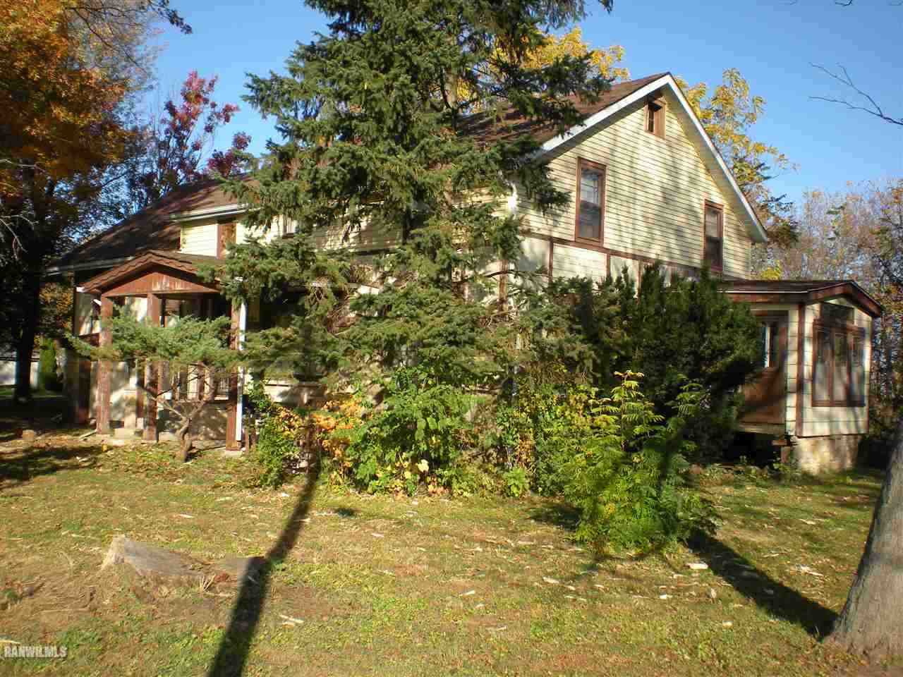 23929 Carroll Road Lanark, IL 61046 - Photo 2 of 25 a yellow house with trees in front of it