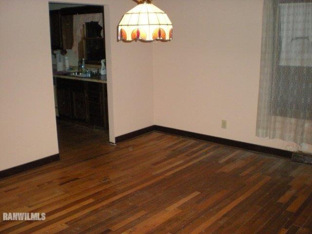 23929 Carroll Road Lanark, IL 61046 - Photo 9 of 25 an empty room with wooden floor and cabinet