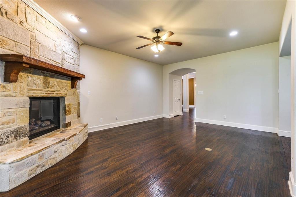 419 Rio Grande Drive Irving, TX 75039 - Photo 10 of 29 Spacious living area featuring rich wood-finish flooring, a stone fireplace with a substantial wood mantel, and recessed lighting